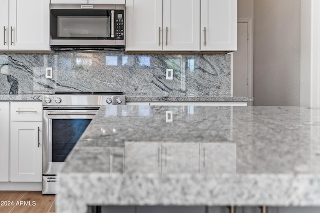 kitchen featuring light stone countertops, appliances with stainless steel finishes, and backsplash