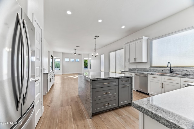 kitchen with a center island, pendant lighting, recessed lighting, appliances with stainless steel finishes, and light wood-style floors