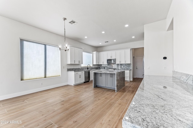 kitchen featuring light wood-style flooring, white cabinetry, visible vents, appliances with stainless steel finishes, and decorative backsplash