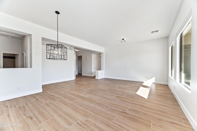 unfurnished living room featuring light wood-type flooring, baseboards, and visible vents