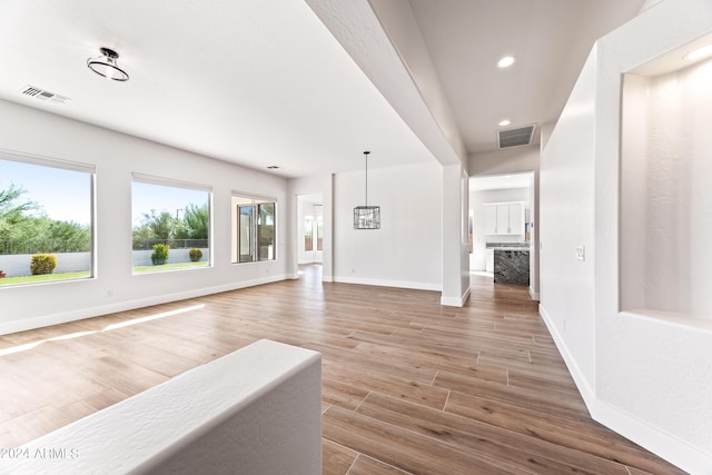 interior space featuring baseboards, visible vents, wood finished floors, and recessed lighting