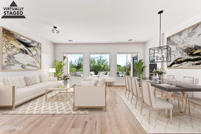 living area featuring light wood finished floors, visible vents, and baseboards