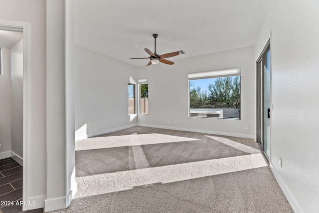 carpeted empty room featuring visible vents, baseboards, and ceiling fan