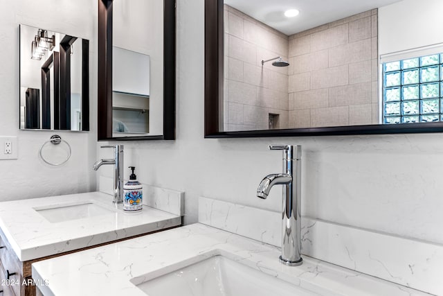 full bath with a tile shower and vanity