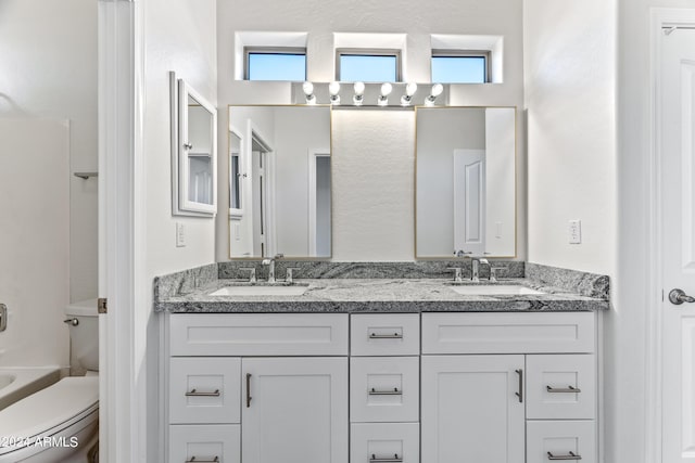 full bathroom featuring a healthy amount of sunlight, a sink, and toilet