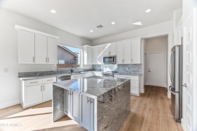 kitchen featuring appliances with stainless steel finishes, visible vents, light wood-style floors, and white cabinetry