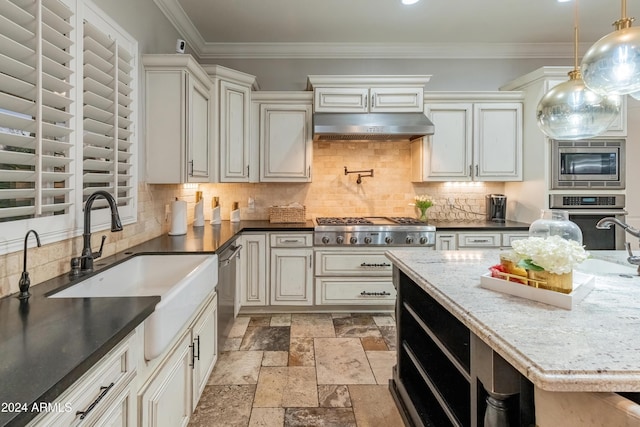 kitchen with appliances with stainless steel finishes, backsplash, dark stone countertops, hanging light fixtures, and range hood