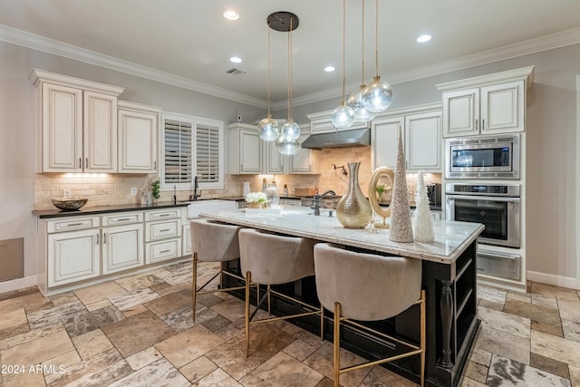 kitchen featuring a kitchen island with sink, dark stone counters, ornamental molding, appliances with stainless steel finishes, and extractor fan