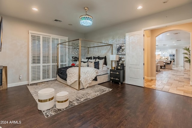 bedroom with wood-type flooring and an inviting chandelier