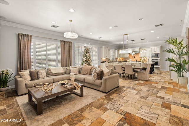 living room featuring a chandelier and ornamental molding