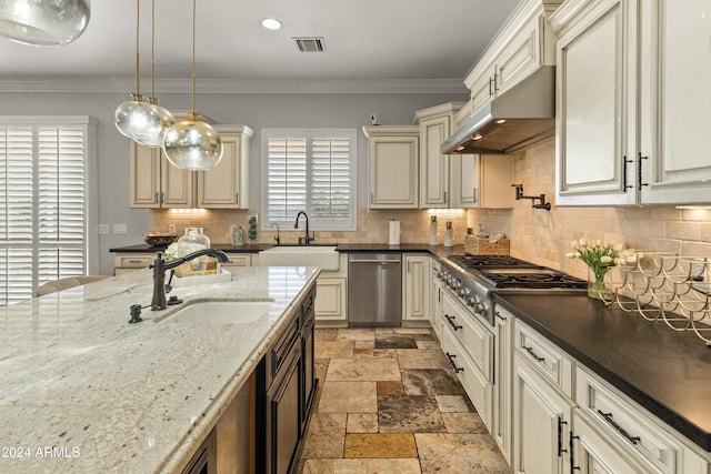 kitchen with dark stone counters, sink, pendant lighting, and appliances with stainless steel finishes