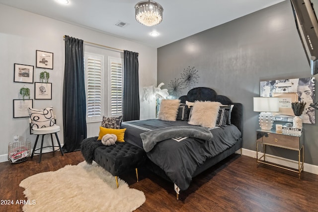 bedroom featuring a chandelier and dark hardwood / wood-style flooring