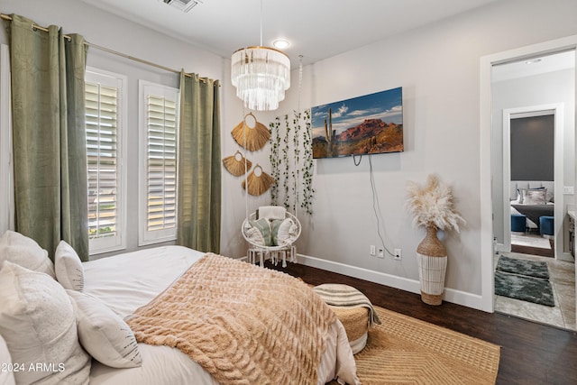 bedroom with dark hardwood / wood-style floors and a notable chandelier