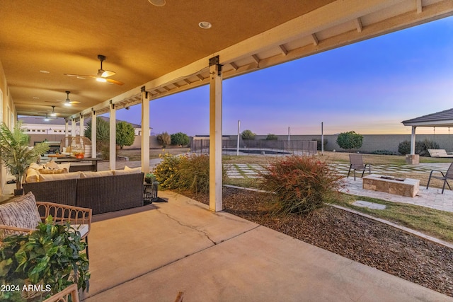 patio terrace at dusk with an outdoor living space and ceiling fan