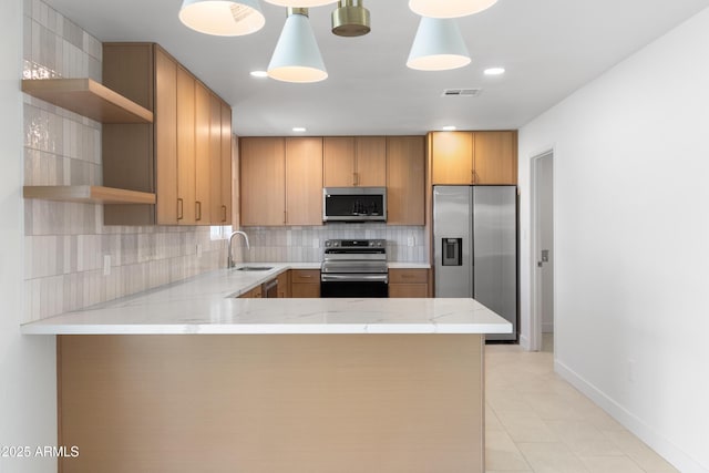 kitchen with visible vents, a peninsula, stainless steel appliances, open shelves, and a sink