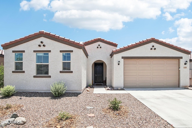 2339 W Sunland Ave, Phoenix, AZ 85041 - mediterranean / spanish-style home with concrete driveway, a garage, a tiled roof, and stucco siding