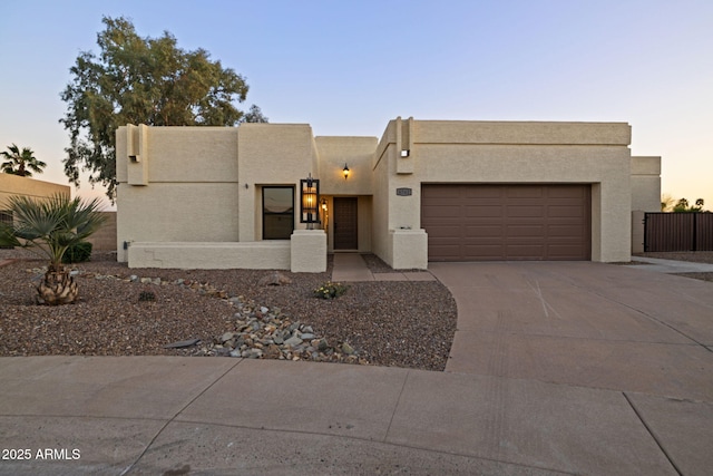 6761 E Juniper Ave, Scottsdale, AZ 85254 - adobe home with concrete driveway, stucco siding, fence, and an attached garage