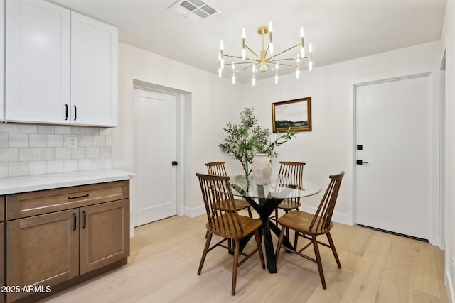 6761 E Juniper Ave, Scottsdale, AZ 85254 - dining space featuring visible vents, baseboards, a chandelier, and light wood-style floors