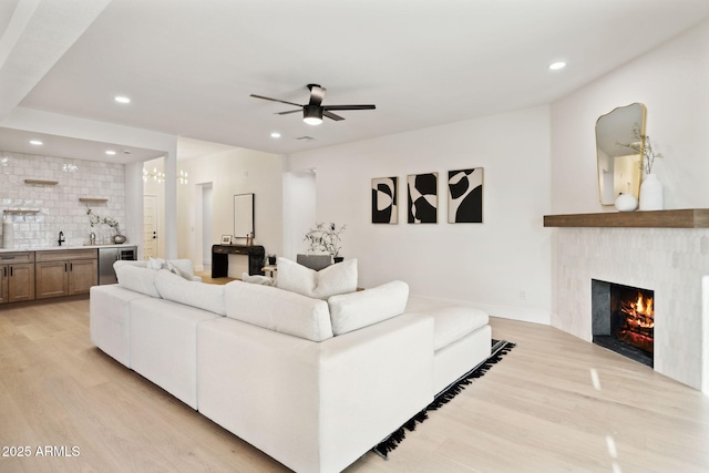 6761 E Juniper Ave, Scottsdale, AZ 85254 - living area with a warm lit fireplace, recessed lighting, wet bar, and light wood-style floors