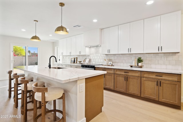 6761 E Juniper Ave, Scottsdale, AZ 85254 - kitchen featuring light wood-style floors, brown cabinets, a sink, and visible vents