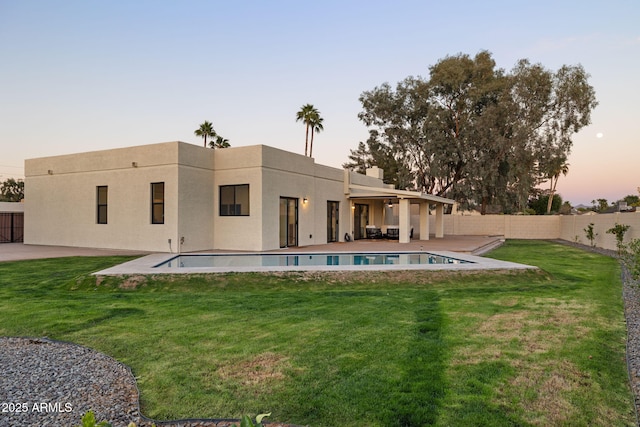 6761 E Juniper Ave, Scottsdale, AZ 85254 - back of house with a yard, a fenced backyard, a patio, stucco siding, and a fenced in pool