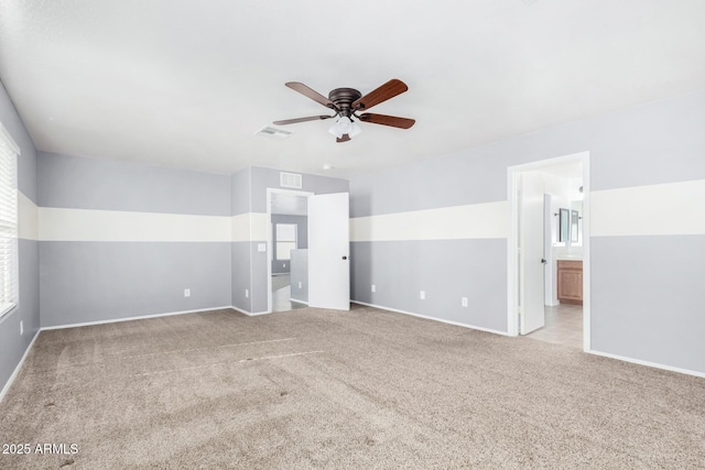 carpeted spare room with a wealth of natural light and ceiling fan