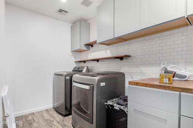 laundry room with cabinets, separate washer and dryer, and light hardwood / wood-style flooring