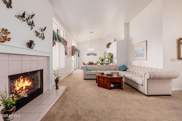 living room with a tiled fireplace, high vaulted ceiling, light colored carpet, and a chandelier