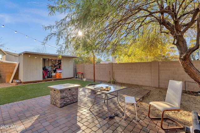 view of patio featuring an outbuilding and a fire pit