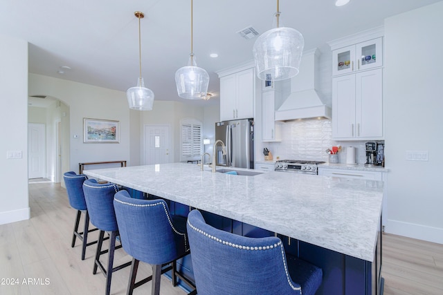 kitchen featuring custom range hood, hanging light fixtures, and a spacious island