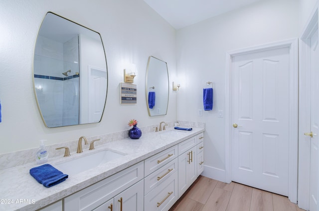 bathroom featuring a shower, vanity, and hardwood / wood-style flooring