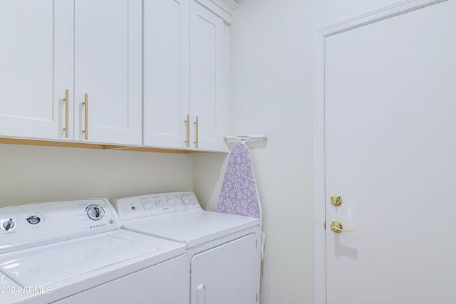 laundry room with washer and clothes dryer and cabinets