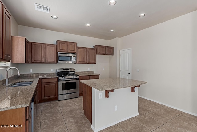 4051 E Torrey Pines Ln E, Chandler, AZ 85249 - kitchen with stainless steel appliances, light tile patterned floors, a kitchen island, recessed lighting, and a kitchen breakfast bar