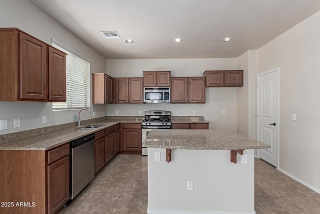 4051 E Torrey Pines Ln E, Chandler, AZ 85249 - kitchen with stainless steel appliances, light tile patterned floors, a center island, recessed lighting, and light stone countertops