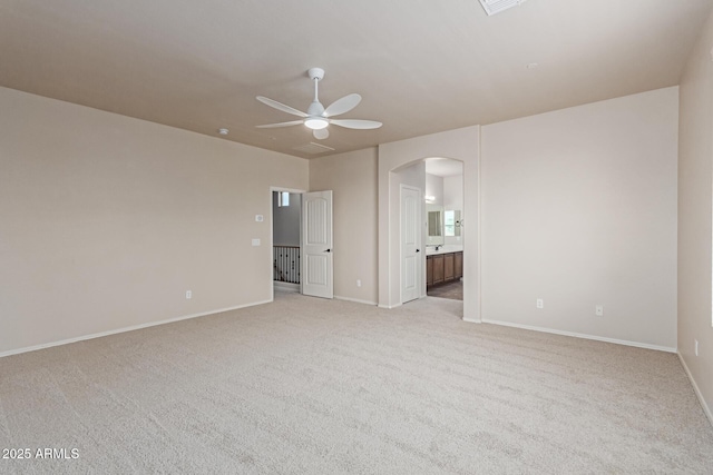 4051 E Torrey Pines Ln E, Chandler, AZ 85249 - unfurnished bedroom featuring arched walkways, light carpet, connected bathroom, and a ceiling fan