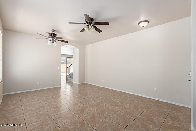 4051 E Torrey Pines Ln E, Chandler, AZ 85249 - empty room featuring light tile patterned floors, a ceiling fan, arched walkways, and stairway