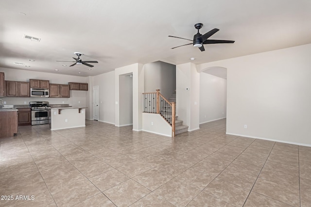 4051 E Torrey Pines Ln E, Chandler, AZ 85249 - unfurnished living room featuring ceiling fan, light tile patterned floors, arched walkways, stairway, and recessed lighting