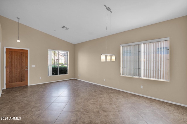 spare room with tile patterned floors and vaulted ceiling