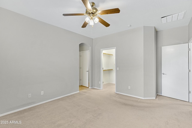 2861 E Morenci Rd, San Tan Valley, AZ 85143 - unfurnished bedroom with arched walkways, light carpet, a spacious closet, and ceiling fan