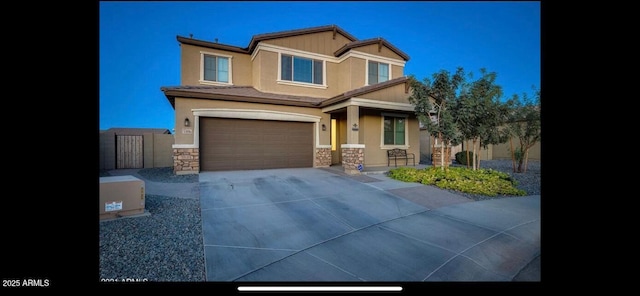 craftsman-style home with an attached garage, stone siding, concrete driveway, and stucco siding