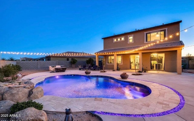 pool at dusk with a patio area