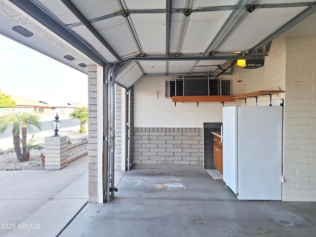 garage featuring white refrigerator and a garage door opener