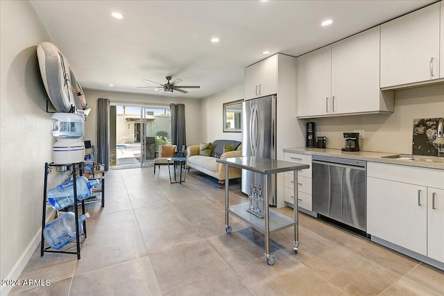 kitchen featuring stainless steel appliances, white cabinetry, ceiling fan, and sink