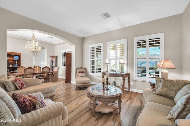 3125 W Desert Ln, Laveen, AZ 85339 - living room featuring arched walkways, a chandelier, and wood finished floors