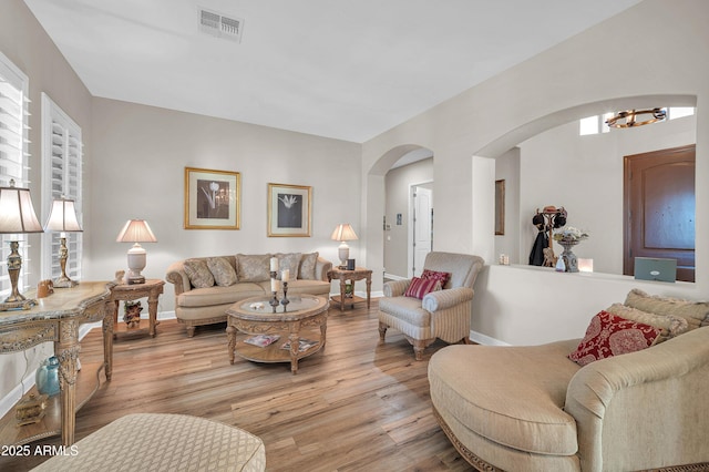 3125 W Desert Ln, Laveen, AZ 85339 - living room featuring arched walkways, a chandelier, and wood finished floors