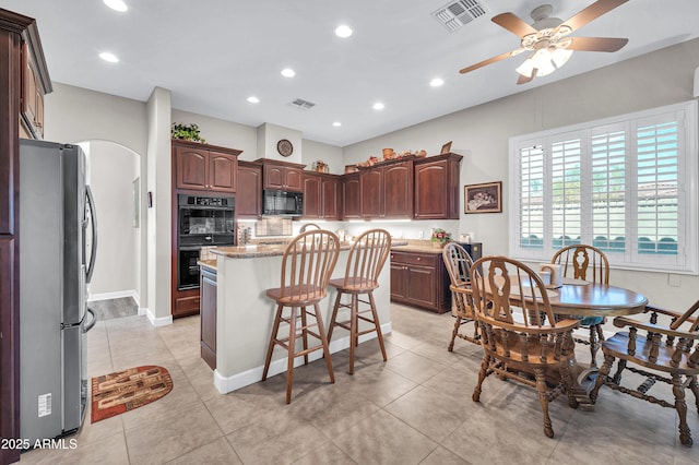 3125 W Desert Ln, Laveen, AZ 85339 - kitchen featuring black appliances, a ceiling fan, a center island, a kitchen bar, and recessed lighting
