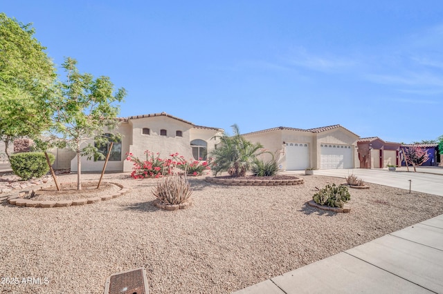3125 W Desert Ln, Laveen, AZ 85339 - mediterranean / spanish-style home featuring concrete driveway, an attached garage, stucco siding, and a tile roof