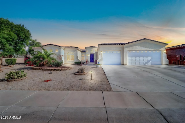 3125 W Desert Ln, Laveen, AZ 85339 - mediterranean / spanish house featuring an attached garage, concrete driveway, stucco siding, and a tile roof