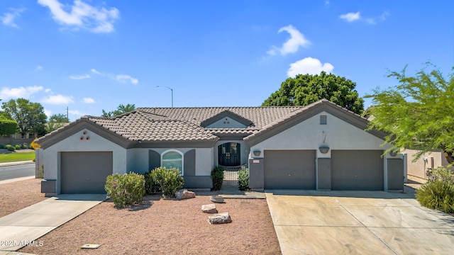 5529 E Holmes Ave, Mesa, AZ 85206 - mediterranean / spanish-style home featuring stucco siding, a tile roof, concrete driveway, and an attached garage