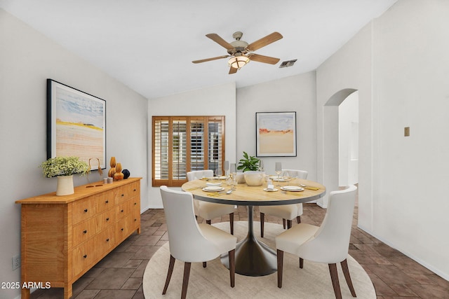 5529 E Holmes Ave, Mesa, AZ 85206 - dining room with arched walkways, vaulted ceiling, stone tile floors, and a ceiling fan